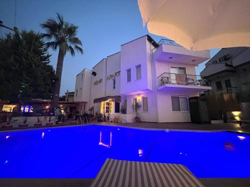a pool in front of a building at night at Nehir Apart Hotel in Fethiye