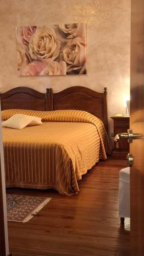 a bedroom with a bed with a painting on the wall at Cascina Lavaroni in Buttrio