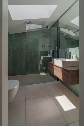 a bathroom with a tub and a sink and a toilet at Mountain View Suites in Tisens