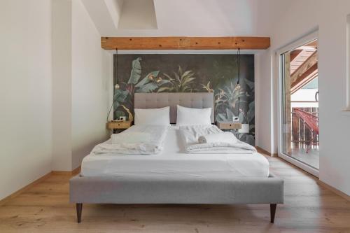 a bedroom with a large bed with a painting on the wall at Mountain View Suites in Tisens