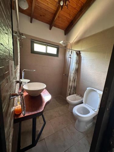 a bathroom with a sink and a toilet and a sink at Al pie de la Sierra in Pueblito