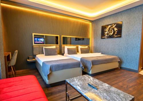 a hotel room with two beds and a red couch at 216 Eagle Palace Suite in Istanbul