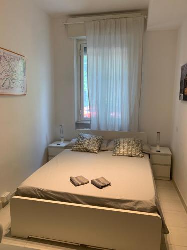 a bedroom with a bed with two pillows and a window at Ripalta House in San Donato Milanese