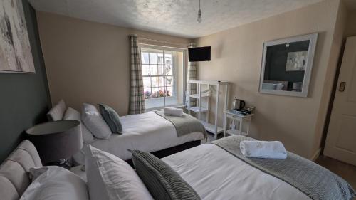 a hotel room with two beds and a window at The Bugle Inn in Bugle