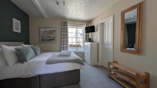 a bedroom with a bed with a mirror and a window at The Bugle Inn in Bugle