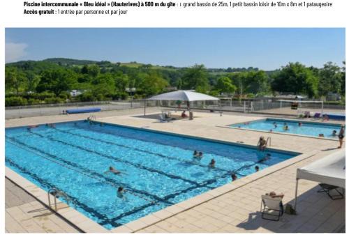 a large swimming pool with people in it at Gîte de la Taillanderie in Hauterives