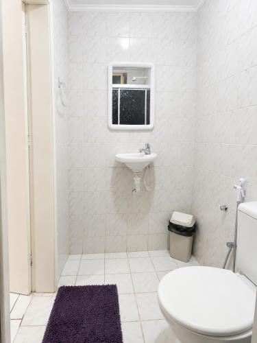 a white bathroom with a toilet and a sink at Center 1 Hotel in Fortaleza