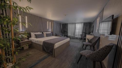 a hotel room with a bed and two chairs at Tryp By Wyndham Istanbul Sancaktepe in Istanbul