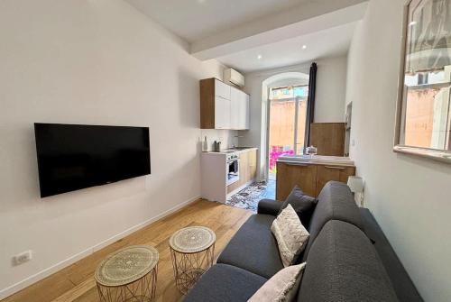 a living room with a couch and a flat screen tv at Casamea - Studio, Terrasse, Clim, Centre hist in Ajaccio