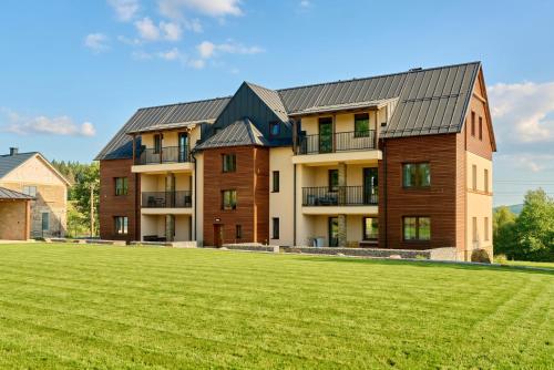 an apartment building with a large grass field at Rezidence George by Mountain ways in Kovářská