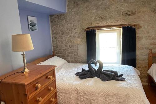 a bedroom with a bed with two swans on it at Rural French Gite Sleeps 8 with Pool and Parking in La Croix-Comtesse