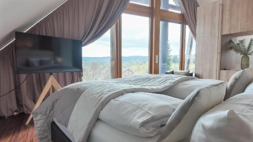 a bedroom with two beds and a large window at Das Marienhöh in Langweiler