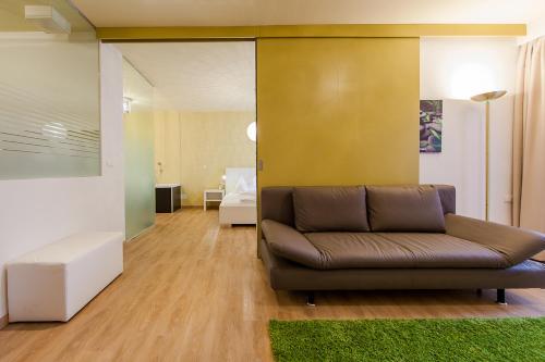 a living room with a couch and a yellow wall at Felderer Boutiquehotel in Caldaro