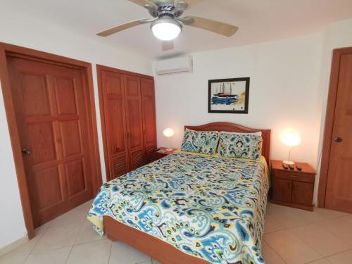 a bedroom with a bed and a ceiling fan at OCEAN SIDE VILLAS and SUITES - playa LOS CORALES in Punta Cana