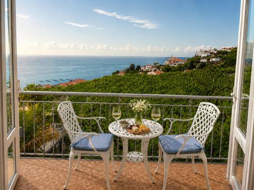 a table and chairs on a balcony with a view of the ocean at Bluegreen in Arco da Calheta
