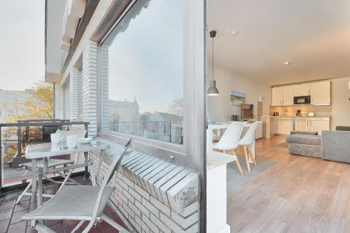 a living room with a balcony with a table and chairs at Düne, App 9 in Duhnen