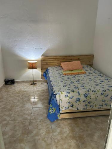a bedroom with a bed and a lamp in it at T1 centro da cidade cif in Luanda