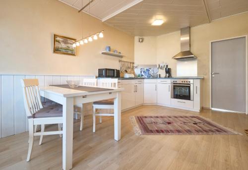 a kitchen with a white table and chairs at Haus Schildt, FeWo 6 in Duhnen