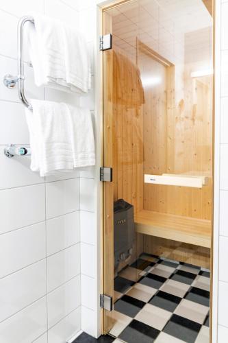 a small bathroom with a shower and a black and white floor at Mora Hotell & Spa in Mora