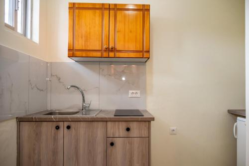 a kitchen with a sink and wooden cabinets at Kalofonos Studios in Laganas