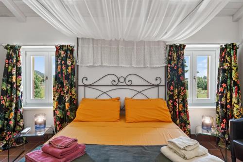 a bedroom with a bed and two windows at Podere il Cavallo Blu in Le Focette