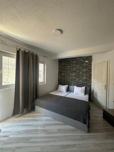 a bedroom with a bed and a brick wall at OneRoom in Ohrid