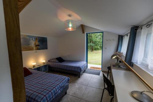 ein Schlafzimmer mit zwei Betten und einem Fenster in einem Zimmer in der Unterkunft Gîte du caché in Labrit