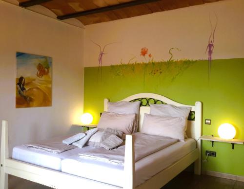 a bedroom with a white bed with a green wall at Finca Alqueria Fosca in Campos