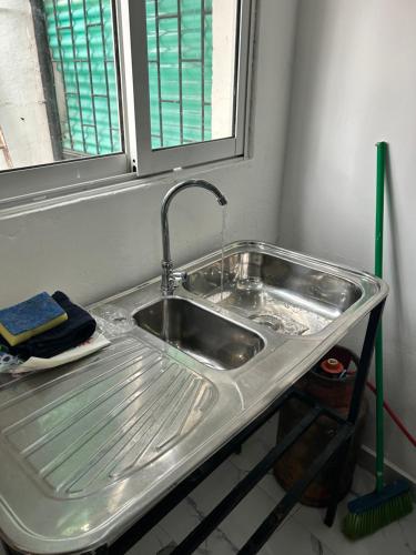 a kitchen sink with a faucet and a window at T1 centro da cidade cif in Luanda