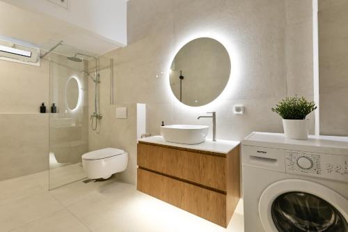 a bathroom with a sink and a washing machine at 'Elan Suites in Preveza