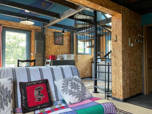 a living room with a couch and a spiral staircase at Les gîtes de la fabrique in Roscanvel