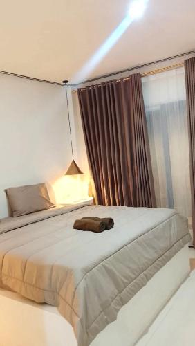 a bedroom with a large white bed with a window at NURBATA HOLDING'S Hostel in Kuta Lombok
