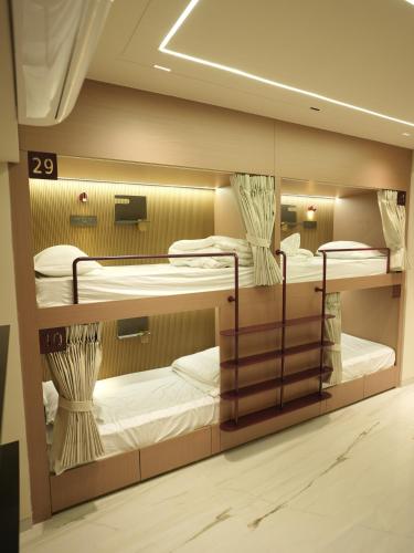 a room with three bunk beds in it at Dormstel - Unit of AHM Hotels & Resorts Pvt Ltd in Vadodara
