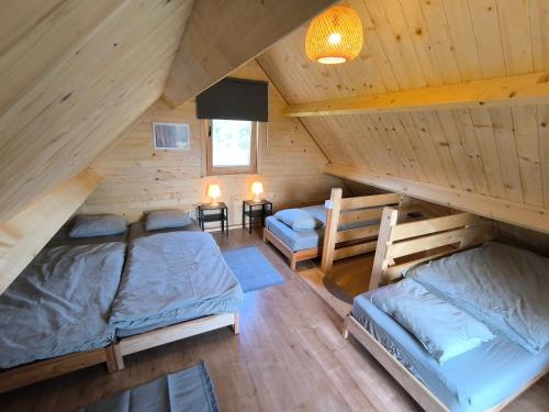 a room with two beds in a wooden cabin at Chata Tisá in Tisá