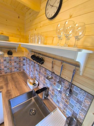 a kitchen with a sink and a clock on the wall at Chata Tisá in Tisá