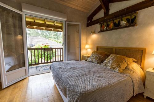 a bedroom with a bed and a large window at L'étable des amis in Escalans