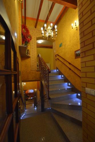 a staircase in a building with a chandelier at Majątek Giże Marczak in Olecko