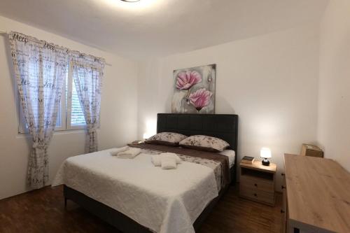 a bedroom with a bed with two towels on it at Apartment Jugo in Preko