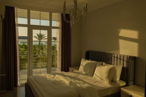 a bedroom with a bed and a large window at Astalanya City in Astara