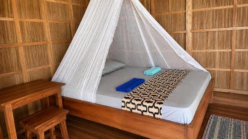 a bed in a sauna with a net at Nyanse Homestay - Raja Ampat in Besir