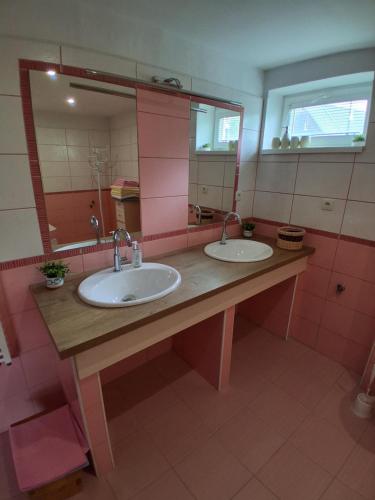 a bathroom with two sinks and a large mirror at Ubytovanie Kubik 473 in Liptovský Mikuláš