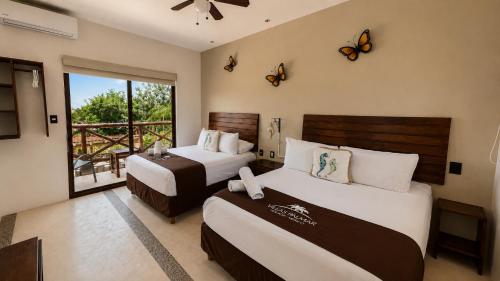 two beds in a room with butterflies on the wall at Villas Palmar Holbox in Holbox Island