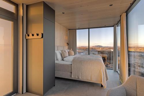 a bedroom with a bed and a large window at ÖÖD Hekla Horizon - Mirror Houses in Hella