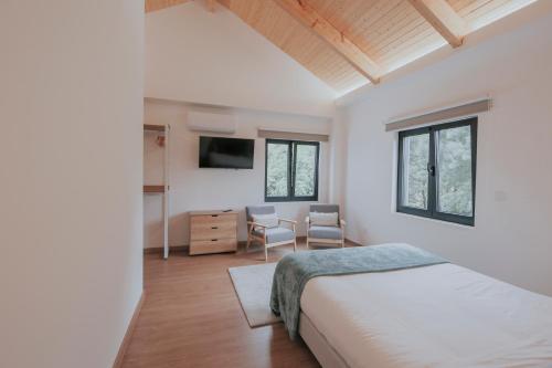 a bedroom with a bed and a table and chairs at Quinta do Codeçal in Vila Real
