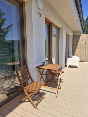 a patio with a table and chairs on a balcony at Apartmán Kľak in Fačkov
