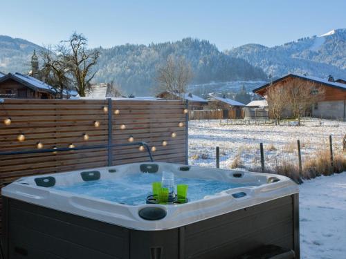 a jacuzzi tub in a yard with snow on the ground at Chalet Bolay in Montriond