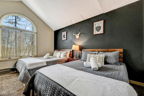 a bedroom with two beds and a large window at Poconos Paradise Lakeskihikewater Parkkids in Lake Harmony
