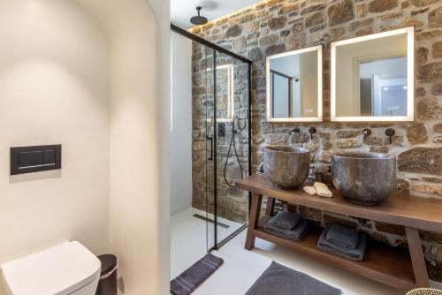 a bathroom with two sinks and two mirrors at Villa RED VENUS in Kalafatis