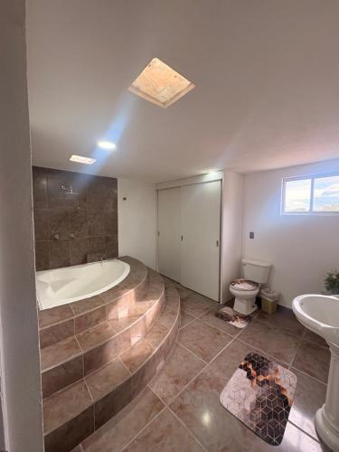 a bathroom with a tub and a toilet and a sink at Casa ejecutiva para 10 personas in Gómez
