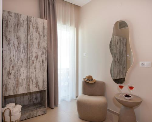a room with a chair and a mirror on the wall at Petra Studios in Palaiochora